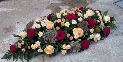 peach and red casket spray