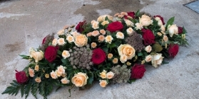 peach and red casket spray